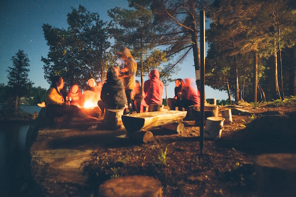 Menschen sitzen am Lagerfeuer | Rabattcoupons