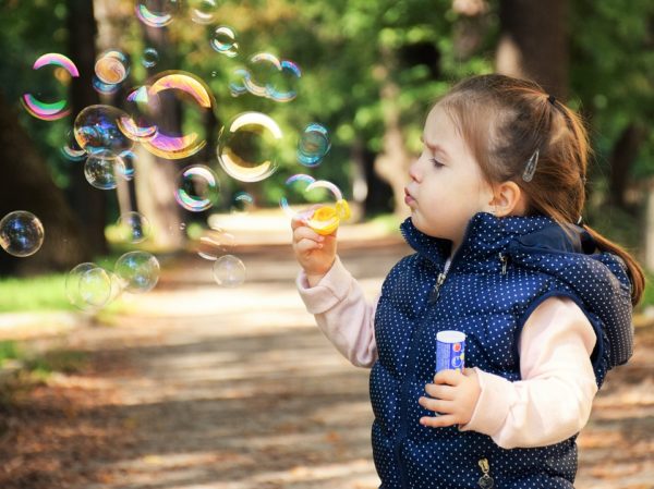 Ein Kind mit Seifenblasen auf einem Weg | Spiele Offensive Gutscheine
