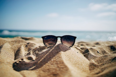 Eine Sonnenbrille liegt auf dem Sand | Marc O'Polo Gutschein