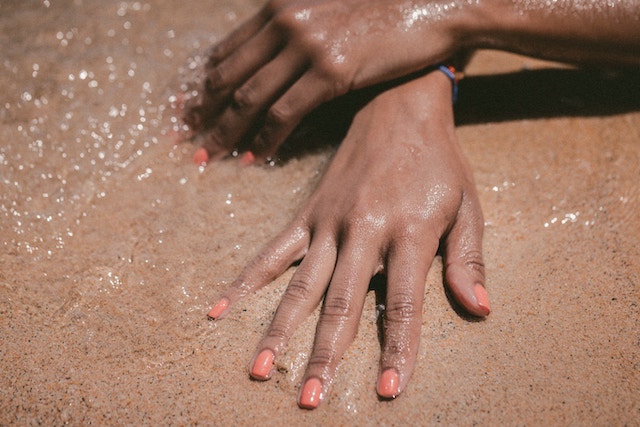 Gepflegte Hände auf dem Sand | Rabatt Coupon