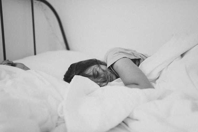 Eine Frau schlafend im Bett | Rabatte Coupon