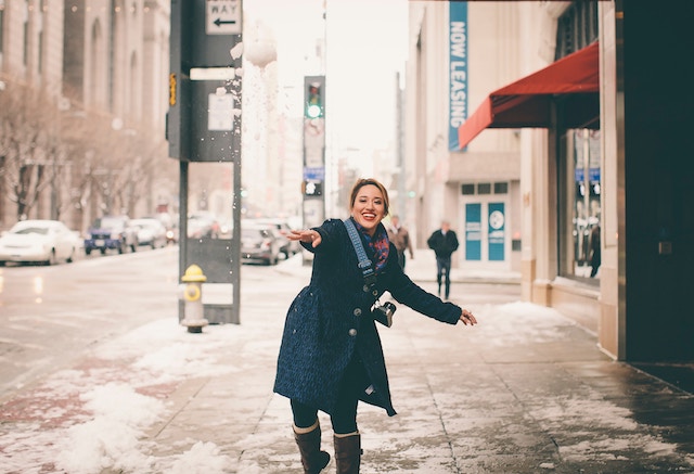 Eine tanzende Frau auf der Straße im Winter | rabatte coupons