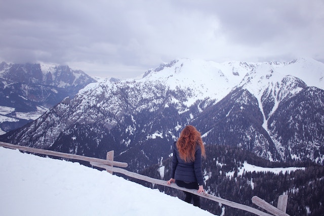 Eine Frau genießt den Anblick von verschneiten Bergen | rabatte coupons