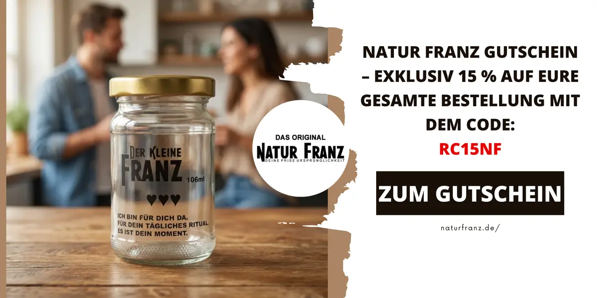 Glas „Der kleine Franz“ auf einem Tisch vor einem unscharfen Paar, daneben Hinweis auf einen Natur Franz Gutschein mit 15 % Rabatt.